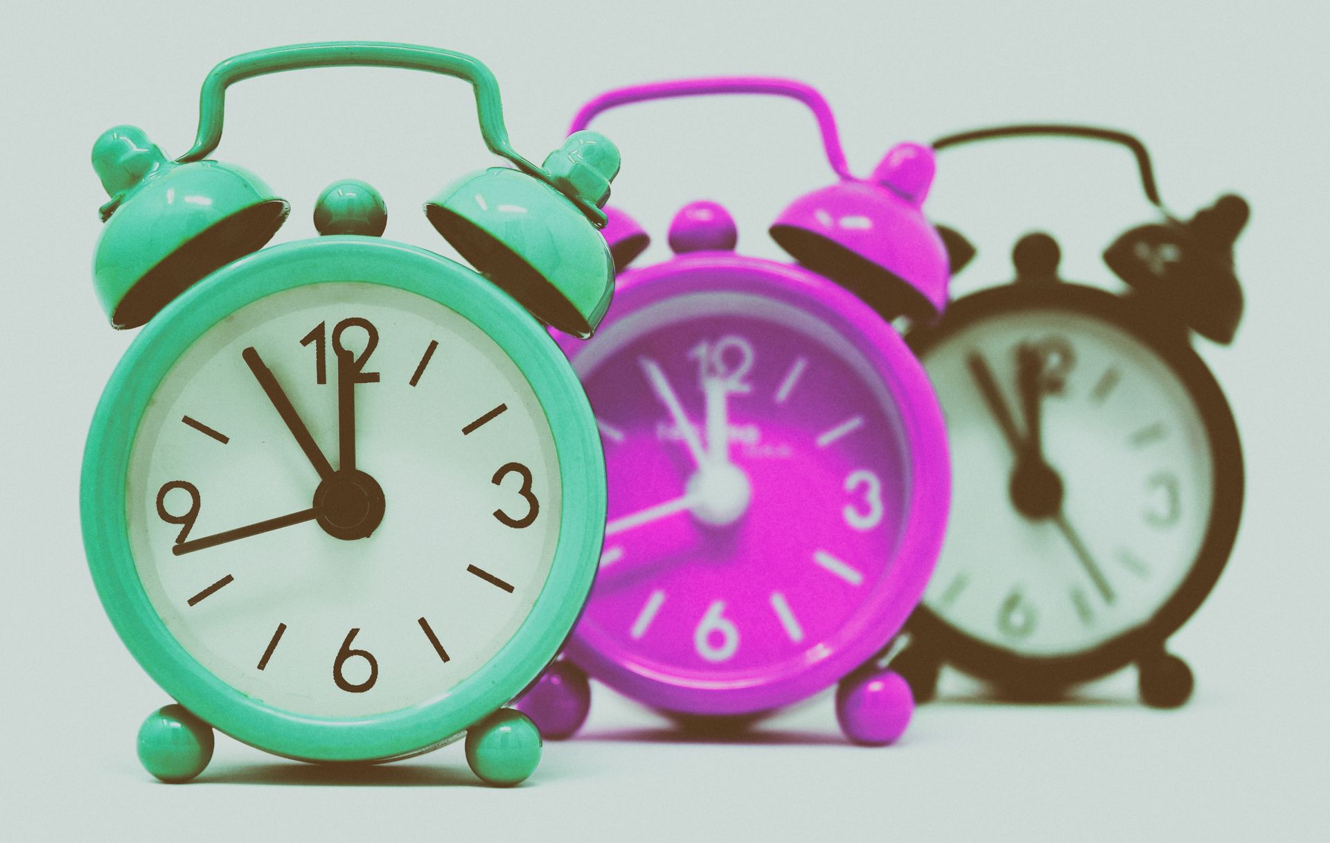 Colorful retro alarm clocks lined up in a row